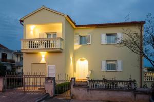 Casa blanca con balcón y valla en Apartments4You en Vodice