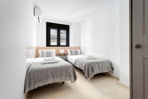 a bedroom with two beds and a window at La Puerta del Mar - Alicante in Alicante