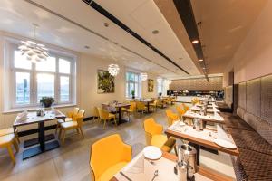 a dining room with tables and yellow chairs at Boutique Hotel Victoria Budapest in Budapest
