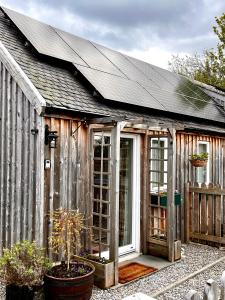 a wooden greenhouse with a window and a roof at Courtyard Bothy in Grantown on Spey