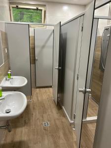 a bathroom with two sinks and a toilet and stalls at Chatový areál ATLAS in Staňkov