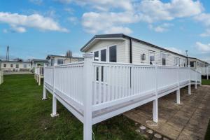a white mobile home with a large deck at Great 8 Berth Caravan With Decking At Valley Farm, Ref 46238pl in Great Clacton