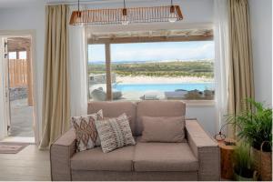 a living room with a couch and a large window at Vouno Luxury Villas in Glinado Naxos