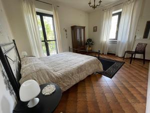 um quarto com uma cama grande e 2 janelas em Casa Tino em Murazzano