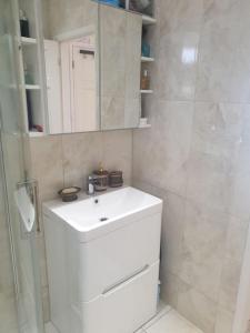 a bathroom with a white sink and a shower at 1 HENDON OLD one in Golders Green