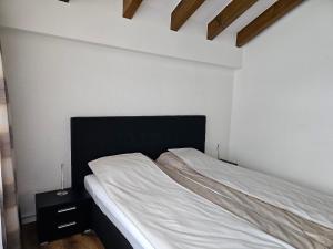 a bedroom with a bed with a black headboard at Rossignol in Zermatt