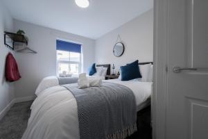 Great Wyrleyにある3 bedroom Cannock flat ideal for groupsの白いベッドルーム(ベッド2台、窓付)
