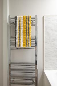 a metal towel rack with yellow and white ties at 3 bedroom Cannock flat ideal for groups in Great Wyrley
