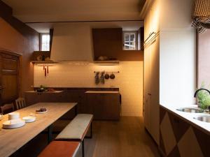 a kitchen with a wooden table and benches in a room at Stately 16-person manor farm in South Limburg in Schimmert