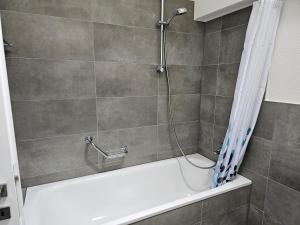 a bathroom with a shower with a white bath tub at Rossignol in Zermatt