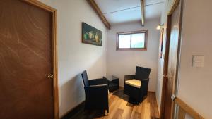 a hallway with two black chairs and a window at Cabañas Manuto Piataro in Hanga Roa