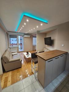 een woonkamer met een keuken met een bank en een tafel bij Centar Lux Apartman in Novi Sad