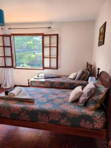 two beds in a room with a window at Gomes house in Ponta do Sol