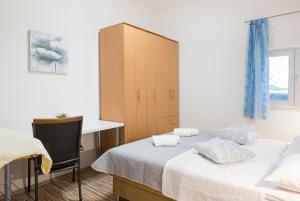 a bedroom with two beds and a desk and a cabinet at Four Hills Apartment in Žrnovnica