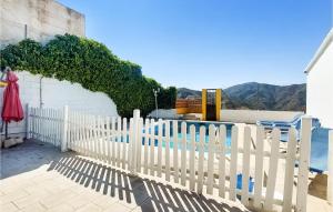 a white picket fence in front of a pool at 4 Bedroom Lovely Home In Almchar in Almáchar