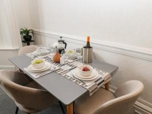 een eettafel met stoelen en een tafel met wijnflessen bij Grand Sea View in North Shields