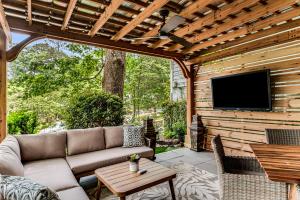 a patio with a couch and a tv on a wooden wall at Pine Lodge Midtown Atlanta - Luxury Oasis, Quiet & Central Location, Beltline & Piedmont Park Steps Away in Atlanta