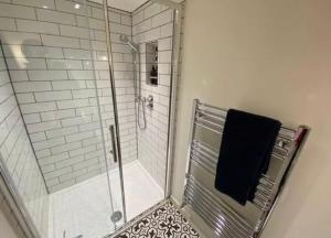 a bathroom with a shower with a black towel at Beautiful Aberaeron Gem in Aberaeron