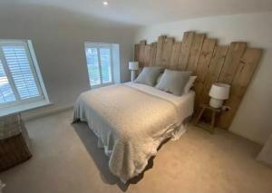 1 dormitorio con 1 cama grande y cabecero de madera en Beautiful Aberaeron Gem en Aberaeron