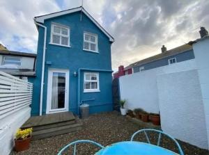 una casa azul con una mesa delante en Beautiful Aberaeron Gem en Aberaeron