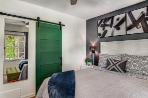 Una puerta verde en un dormitorio con cama en Pine Lodge Atlanta - Luxe Atlanta Home Near Everything Hot Tub Patio, en Atlanta