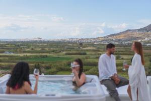 a group of people sitting in a hot tub at Vouno Luxury Villas in Glinado Naxos