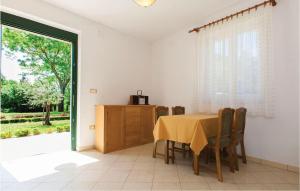 a dining room with a table and chairs and a window at Pet Friendly Home In Valbandon With Kitchen in Fondole