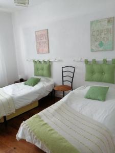 2 bedden met groene kussens in een kamer bij Maison des Agapanthes PLENEUF VAL ANDRE in Pléneuf-Val-André