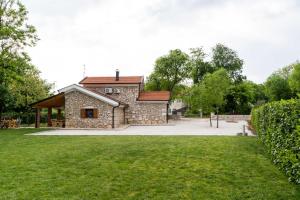 a stone house with a pavilion in a park at Kamena Kuća Vegar in Ljubuški