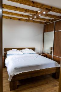 a bedroom with a large bed with white sheets at Kamena Kuća Vegar in Ljubuški