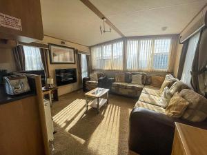 a living room with a couch and a tv at Lovely Caravan With Decking Nearby Scratby Beach In Norfolk Ref 50031j in Great Yarmouth