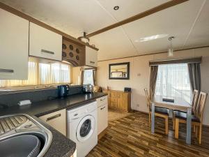a kitchen with a sink and a washing machine at Lovely Caravan With Decking Nearby Scratby Beach In Norfolk Ref 50031j in Great Yarmouth