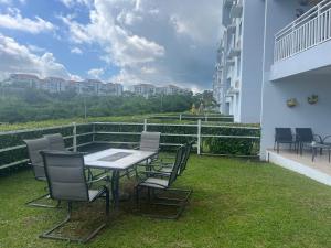 een tafel en stoelen op het balkon van een gebouw bij Relaxing Hillside Village Apartment in Rio Grande