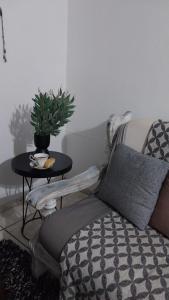 a living room with a couch and a table with a plant at Log in At 118 Self Catering Unit 2 in Meyerton