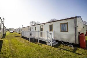 uma fila de casas móveis estacionadas num campo em 8 Berth Caravan With Decking At Sunnydale In Lincolnshire Ref 35087s em Louth