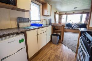 a small kitchen with a sink and a stove at 8 Berth Caravan With Decking At Sunnydale In Lincolnshire Ref 35087s in Louth
