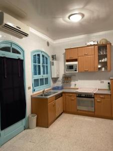a kitchen with wooden cabinets and a stove top oven at Maison la perle de Hammam Sousse in Hammam Sousse