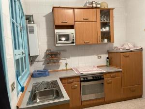 a small kitchen with a sink and a microwave at Maison la perle de Hammam Sousse in Hammam Sousse