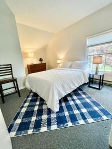 een slaapkamer met een groot bed met een blauw en wit tapijt bij Walk to the Outfield of Lime Rock Park in Salisbury
