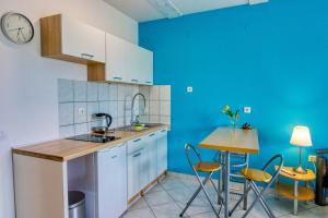 a kitchen with blue walls and a table and chairs at Apartman Studio in Pula