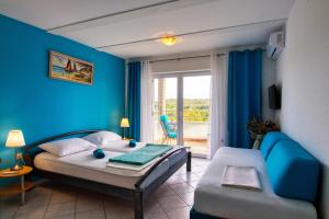 a bedroom with blue walls and a bed and a couch at Apartman Studio in Pula
