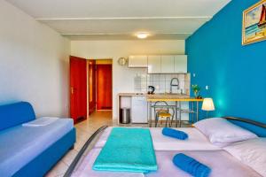 a living room with two beds and a kitchen at Apartman Studio in Pula