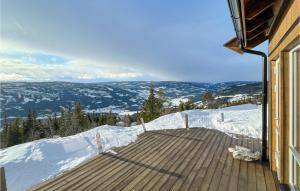 a house with a wooden deck in the snow at 3 Bedroom Stunning Home In Aurdal in Aurdal