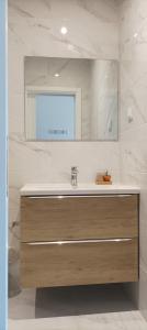 een badkamer met een wastafel en een spiegel bij SulSeixe Guesthouse in Odeceixe