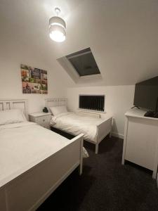 um quarto com 2 camas e uma luz e uma janela em Stunning & Fun 4 bed home in the heart of Brighton em Brighton & Hove