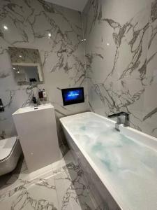 uma casa de banho com banheira e uma televisão na parede em Stunning & Fun 4 bed home in the heart of Brighton em Brighton & Hove