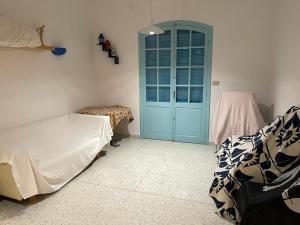 a bedroom with a blue door and a bed at Maison la perle de Hammam Sousse in Hammam Sousse