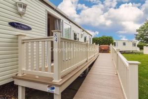 a wooden walkway leading to a house at 6 Berth, Wheelchair Adapted Caravan At Southview Holiday Park Ref 33084s in Skegness