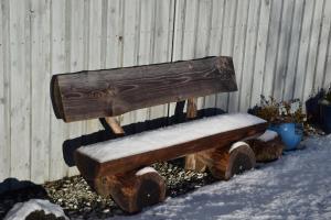 a wooden bench covered in snow next to a fence at Tigh Eilidh (The Cabin on the Hill) in Breakish