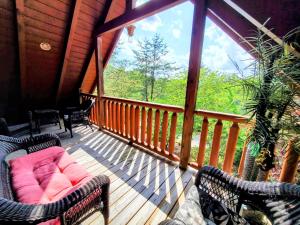 a porch with two chairs and a couch on a deck at Airport Runway 33 in Pigeon Forge